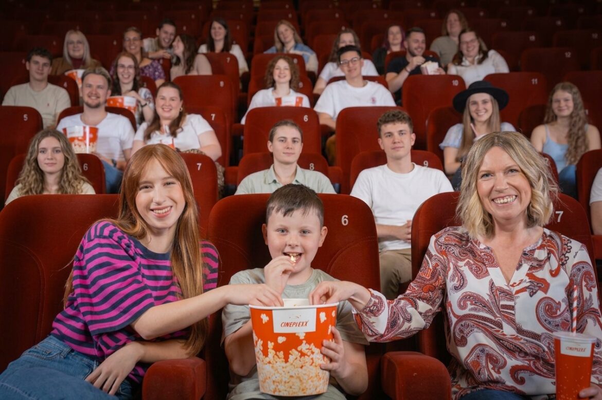 Familie und weitere Kinogäste mit Popcorn in einem Cineplexx-Kinosaal, Symbolfoto
