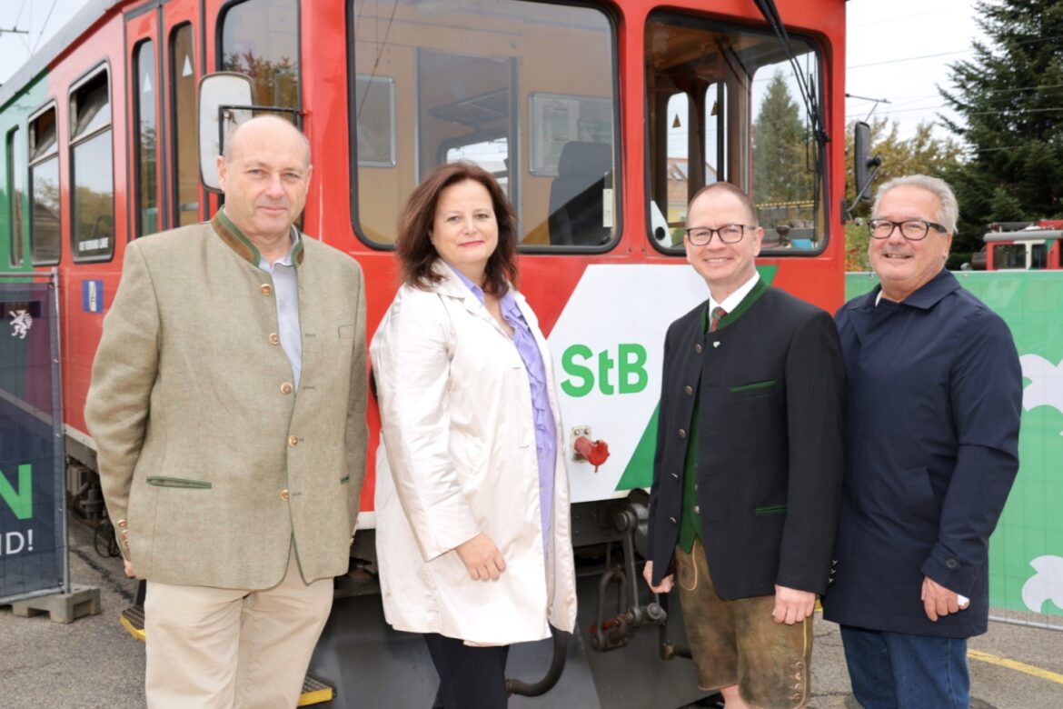 Vier Vertreterinnen und Vertreter beim 95-Jahre-Jubiläum der Gleichenberger Bahn vor einem Zug am 9. Oktober 2026