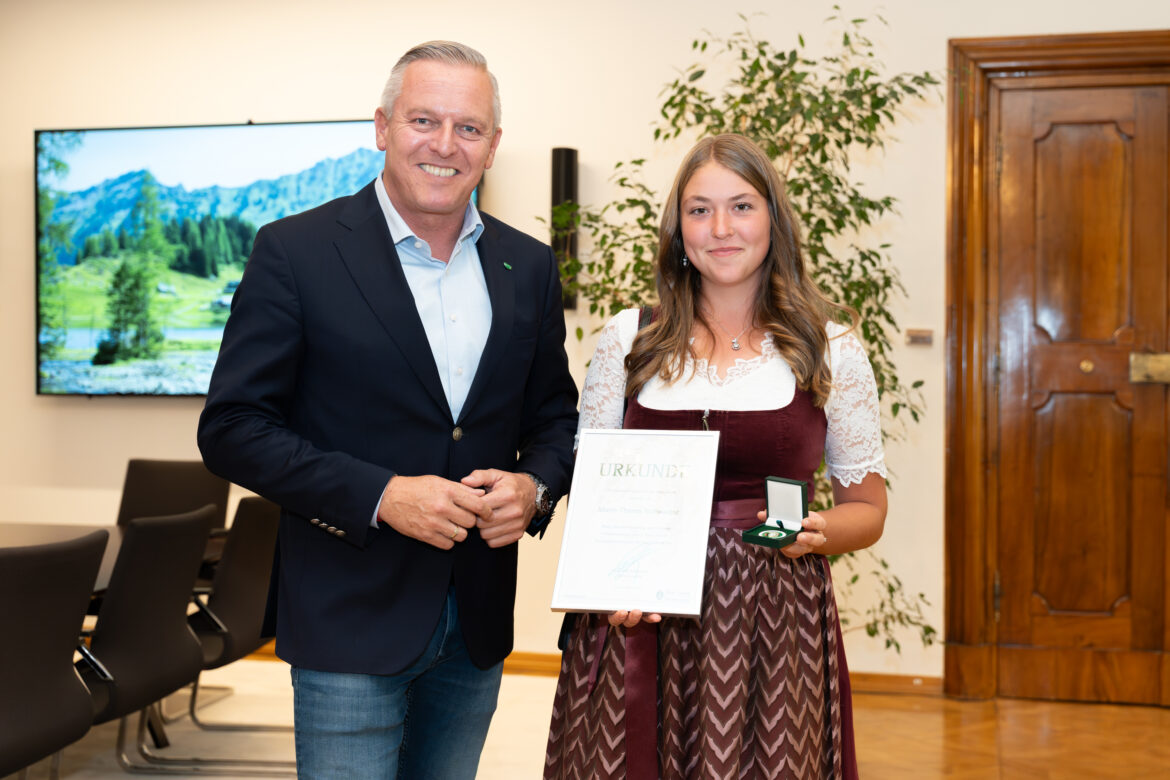 Marie-Theres Schwaiger mit Urkunde und Medaille neben Landeshauptmann Mario Kunasek.