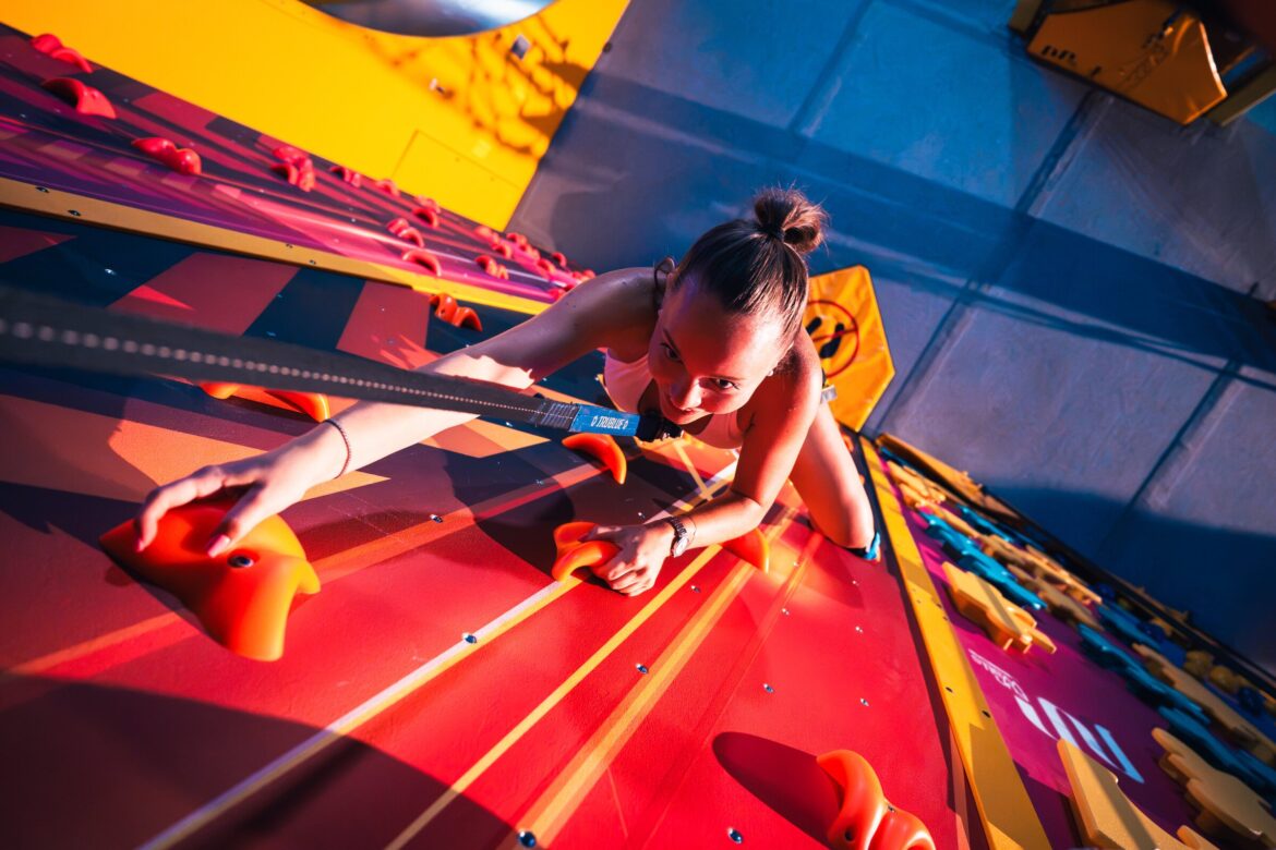 Besucherin an einer Kletterwand im Funpark von WOOP! Graz