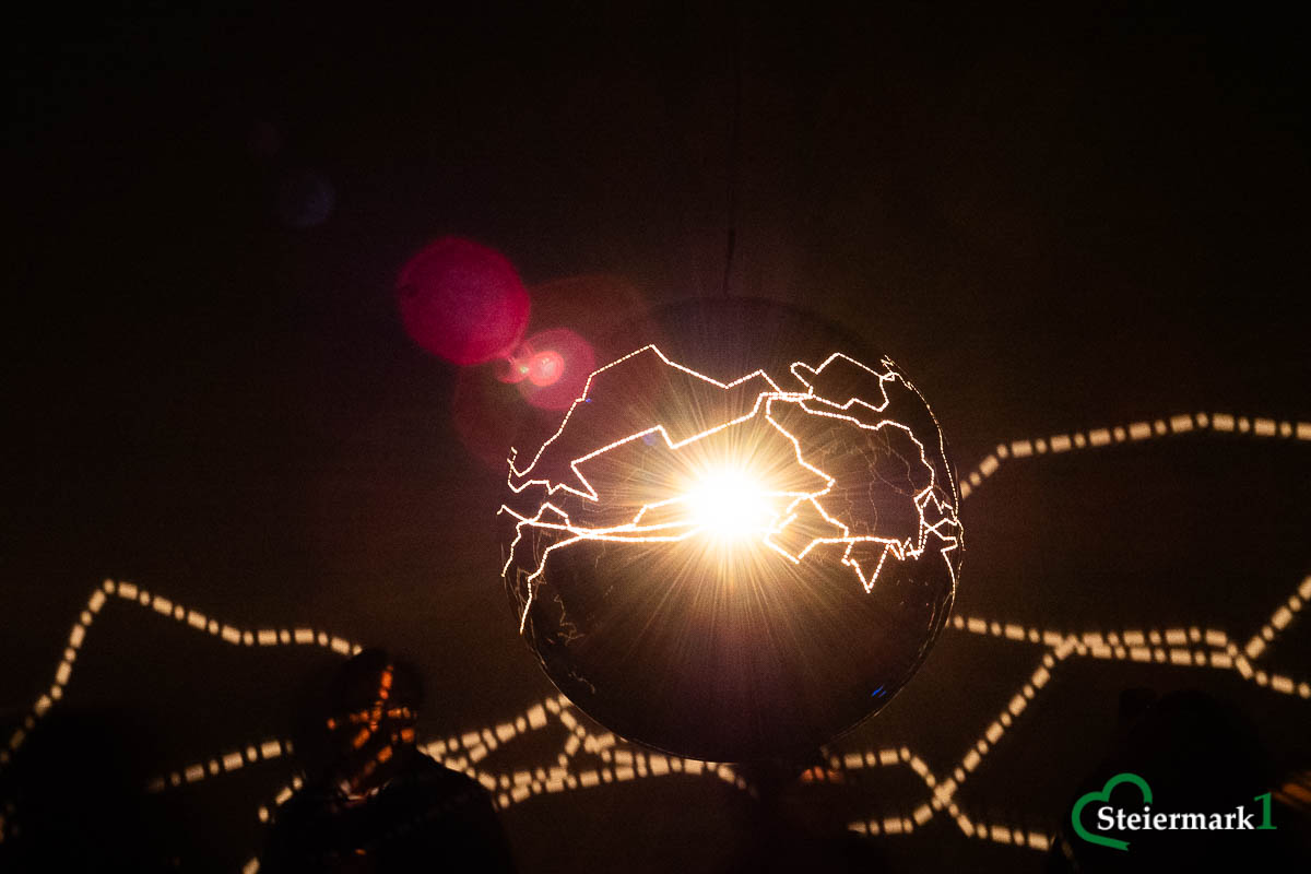 Licht dringt durch die geschwungenen Öffnungen der hängenden Kugel von Helga Griffiths’ „Migratory Senses“ in Schloss Eggenberg.